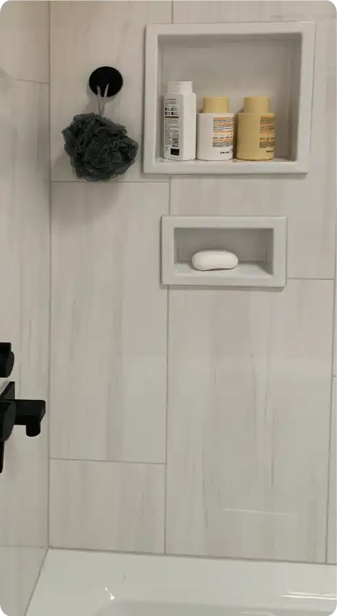 Built-in shower niche with bathroom products and a loofah.